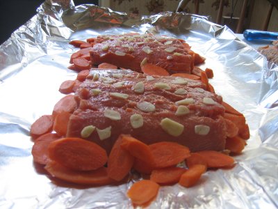 Lemon juice and garlic put on filets. Carrots placed around them.